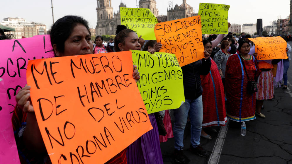 Grupo de manifestantes portando pancartas en contra del hambre